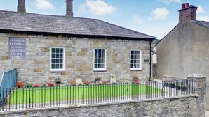 A stone building with a sign reading "National School Erected A.D.1816". - 2 Bed in Beaumaris (oc-wai206) (Beaumaris)
