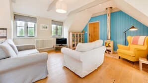 Ein gemütliches Wohnzimmer im Loft-Stil mit Kamin, Fernseher und Bücherregal.