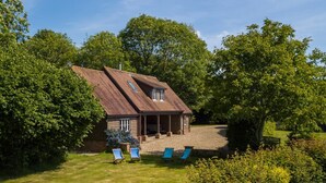 Ein Haus mit Satteldach, überdachter Veranda und einem Schotterweg.