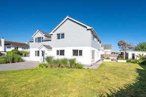 A two-story house with a front porch, a driveway, and a well-maintained lawn. - 6 Bed in Constantine Bay (oc-p00571) (Constantine Bay)