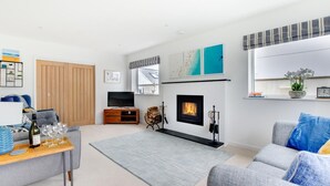 Una sala de estar moderna con chimenea, televisión y sofá.