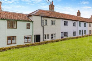 A row of terraced houses with a grassy front yard.