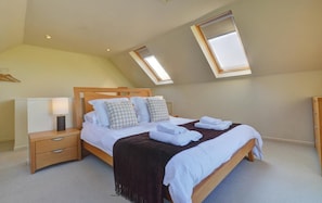 A bedroom with a bed, bedside tables, a lamp, and two skylights. - 3 Bed in Salthouse (oc-1753) (Salthouse)
