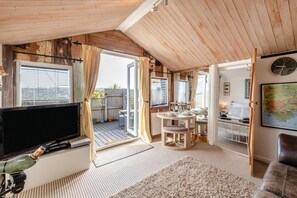 A cozy room with a TV, a wooden ceiling, a dining area, and a bed. - 1 Bed in Totnes (oc-bc1000) (Totnes)