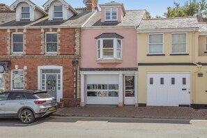 Une rangée de maisons à trois étages, avec un garage au milieu.