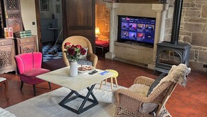 Una sala de estar acogedora con chimenea, televisor y asientos cómodos.