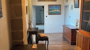 Una habitación acogedora con una mesa de madera, un banco y un cuadro grande en la pared.
