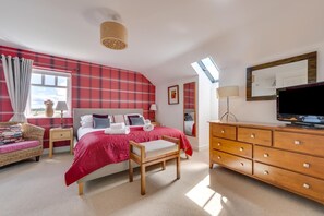 A spacious bedroom with a large bed, a wooden dresser, a television, and a window with a view. - 5 Bed in nr Beadnell (oc-565945) (Beadnell)