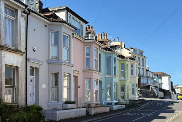 A row of colorful terraced houses with a clear street in front. - 4 Bed in Brixham (oc-b33461) (Brixham)