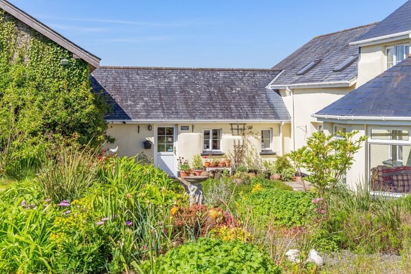 A house with a garden, a visible door, and a window.
