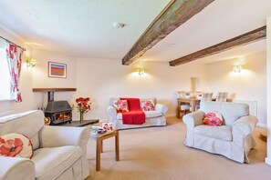 A cozy living room with a fireplace, two sofas, a dining table, and a coffee table.