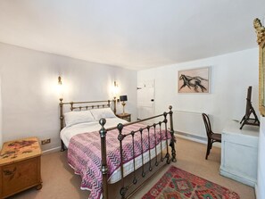 A bedroom with a four-poster bed, a desk with a chair, a radiator, and a painting on the wall. - 2 Bed in Burnham Market (oc-j33432) (Burnham Market)