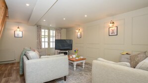 A living room with two sofas, a coffee table, a TV, and a window with curtains. - 3 Bed in Petrockstow (oc-n33541) (Petrockstow)