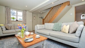 A living room with two sofas, a wooden coffee table, and a staircase. - 3 Bed in Petrockstow (oc-n33541) (Petrockstow)