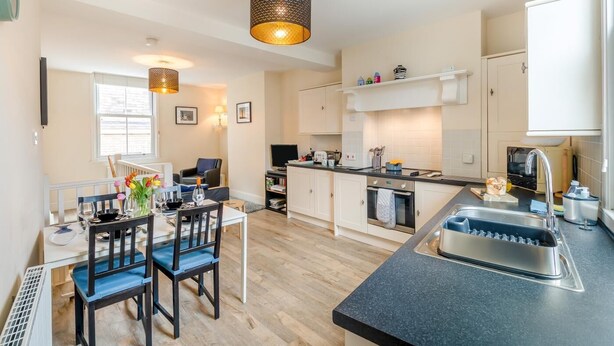 A modern kitchen with a dining area, a built-in oven, and a sink. - 2 Bed in Whitby (oc-w402) (Whitby)