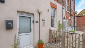 A residential building with a white door, a mailbox, a small garden with potted plants, and a wooden fence. - 2 Bed in Whitby (oc-w402) (Whitby)