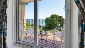 A balcony with a view of the sea, a table with chairs, and a bottle of champagne. - 2 Bed in Langland (oc-hh1005) (Newton)
