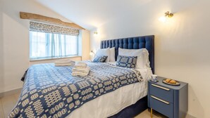A bedroom with a bed, pillows, a bedside table, and a window. - 3 Bed in Moylegrove (oc-s33507) (Cardigan)