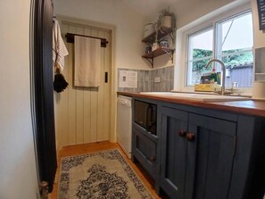 A compact kitchen with a built-in oven, a window with a view, and a wooden countertop. - 2 Bed in Pickering (oc-y110) (Pickering)