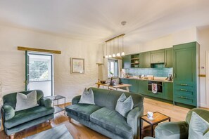 Ein Wohnzimmer mit einer Couch und einem Essbereich mit Tisch und Stühlen.