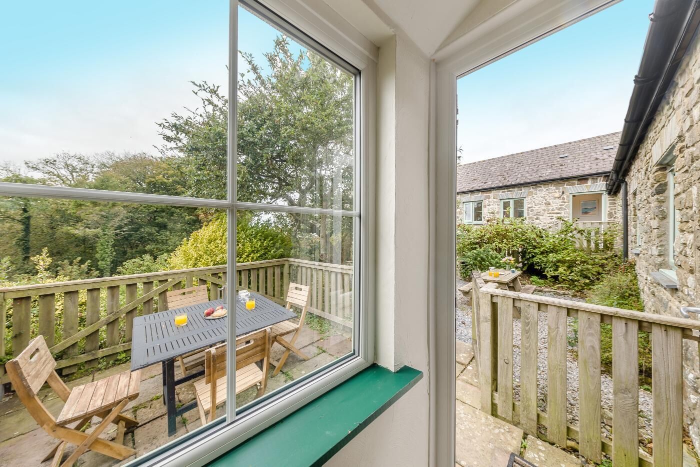 A room with a large window, a wooden table with chairs, and a bench.