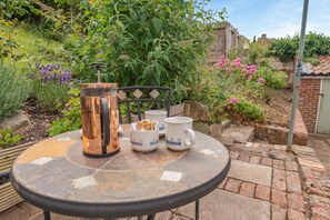 A round table with a coffee pot, two cups, and a small bowl with bread. - 4 Bed in Whitby (oc-w084) (Whitby)