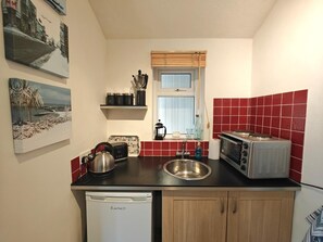 Eine kleine Küche mit Geschirrspüler, Toaster und Spüle.