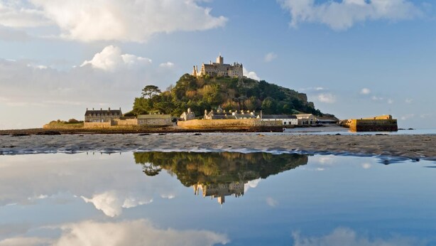A castle on a hill with a moat and a reflection in the water. - 2 Bed in Marazion (oc-p00598) (Marazion)