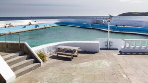 A pool area with a view of the sea, steps leading down to the water, and a picnic table. - 2 Bed in Marazion (oc-p00598) (Marazion)
