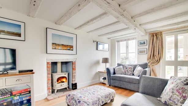 A cozy living room with a fireplace, a sofa, a television, and a bookshelf. - 2 Bed in Snape (oc-sfbox) (Snape)