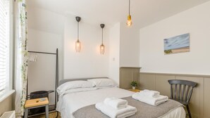 A hotel room with a bed, bedside table, chair, and a painting on the wall. - 2 Bed in Holt (oc-2231) (Holt)