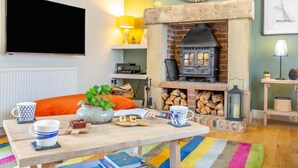 A cozy living room with a fireplace, a flat-screen TV, and a comfortable seating area. - 3 Bed in nr Beadnell (oc-cr1279) (Beadnell)