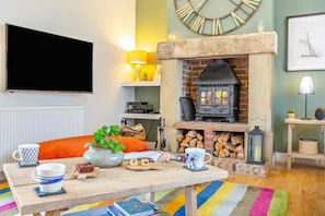 A cozy living room with a fireplace, a flat-screen TV, and a comfortable seating area. - 3 Bed in nr Beadnell (oc-cr1279) (Beadnell)