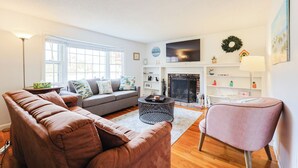 Un salon avec un canapé, un fauteuil et une cheminée.