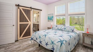Una camera da letto con un letto grande, un armadio con porta scorrevole in legno e vista sull'esterno, oltre a una finestra con persiane.