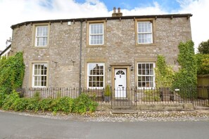 A stone building with a symmetrical facade, multiple windows, and a central door. - 5 Bed in Kettlewell (oc-ds257) (Kettlewell)