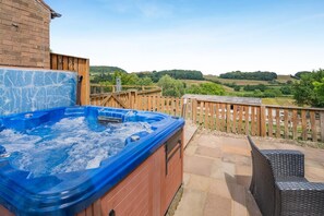 A hot tub on a patio with a view of rolling hills. - 4 Bed in Suffield (oc-sa013) (Suffield)