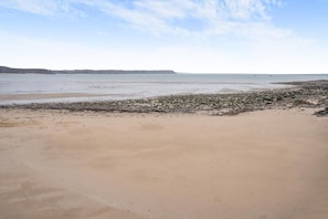 A beach with a sandy shore and rocky outcrops. - 5 Bed in Oxwich (oc-g31916) (Oxwich)
