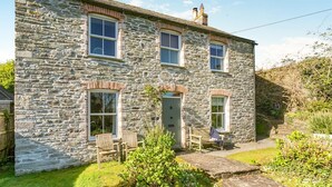 A stone house with a front porch, two windows, and a door. - 4 Bed in St. Mawgan (oc-p00610) (Saint Mawgan)