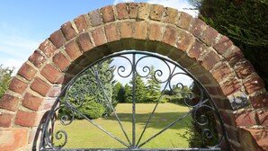 An arched brick entrance with a metal gate.