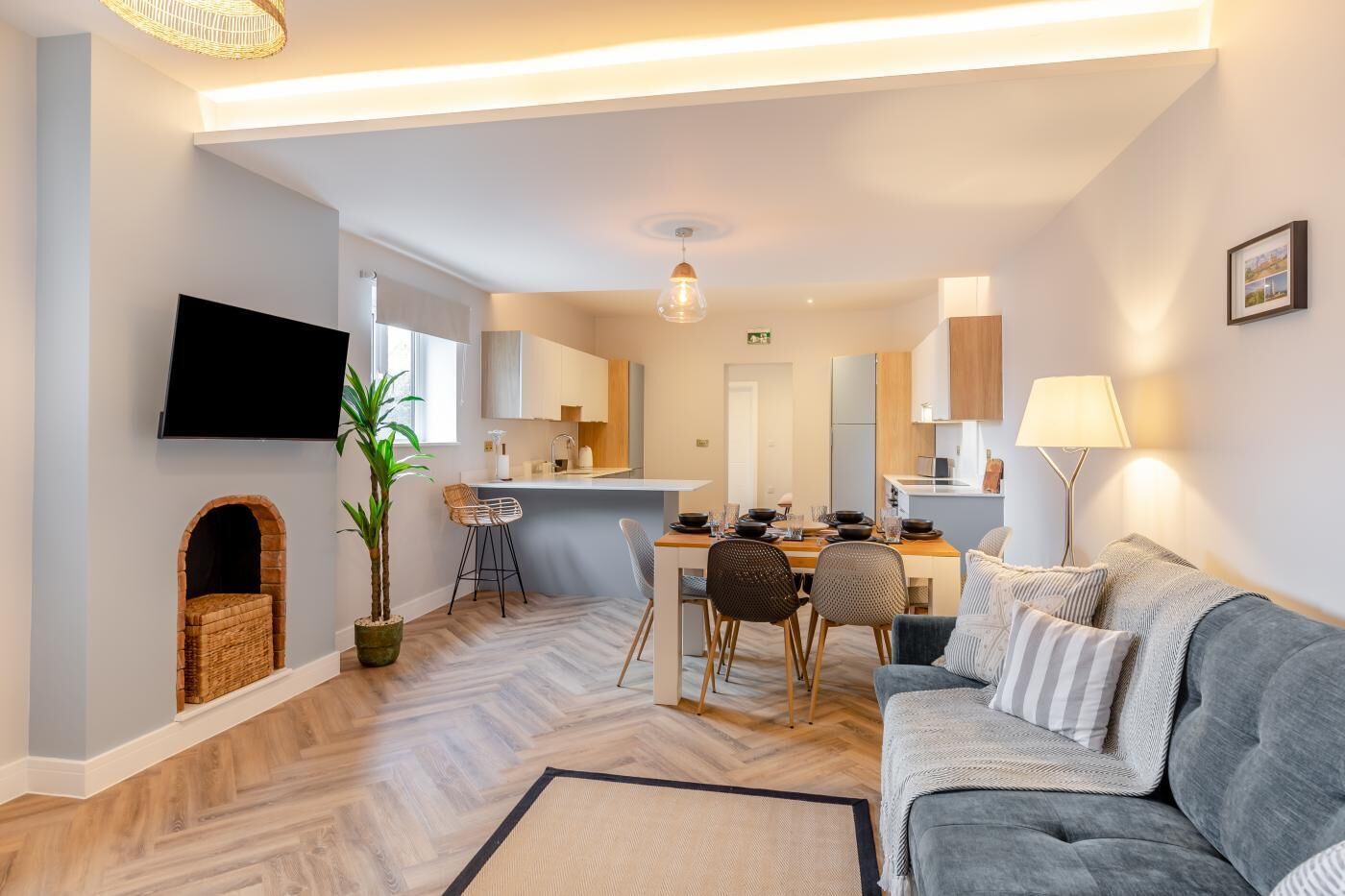 A modern apartment with a dining area, kitchen, and living room.