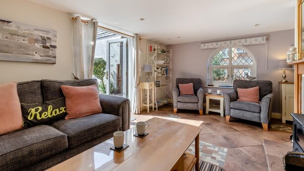A living room with a sofa, two armchairs, a coffee table, and a bookshelf. - 2 Bed in Weybourne (oc-1789) (Weybourne)