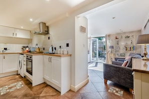 A modern kitchen with white cabinetry, a built-in oven, and a coffee machine. - 2 Bed in Weybourne (oc-1789) (Weybourne)