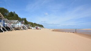 Ein Strand mit Holzstrandkörben und wolkenlosem Himmel.