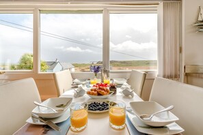 A breakfast table with croissants, blueberries, and orange juice, overlooking a scenic landscape. - 2 Bed in Penally (oc-pw9077) (Penally)