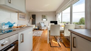 A modern kitchen with a dining area, large windows, and a view of the outdoors. - 2 Bed in Penally (oc-pw9077) (Penally)