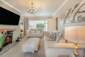 A living room with a fireplace, sofa, and TV. - 3 Bed in Pentlepoir (oc-a33527) (Saundersfoot)