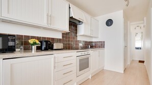 A kitchen with white cabinets, a microwave, a toaster, and a clock on the wall. - 1 Bed in Langland (oc-hh1423) (Newton)