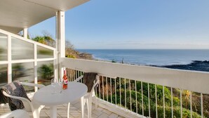 A balcony with a table and chairs, overlooking a coastal view. - 1 Bed in Langland (oc-hh1423) (Newton)
