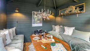 A cozy room with a wooden ceiling, a chandelier, a dining table set with food and drinks, and a framed picture on the wall. - 2 Bed in Ladybank (oc-n33092) (Letham)
